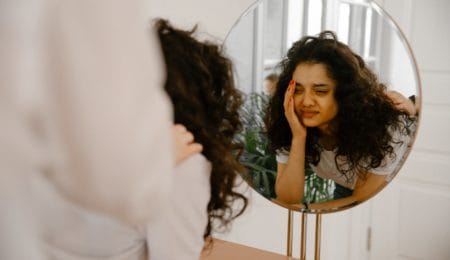 mulher com autoestima baixa se olhando no espelho