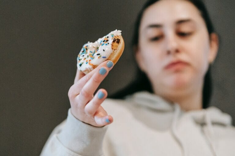 moça triste comendo donnut