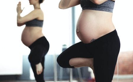 mulher grávida praticando yoga
