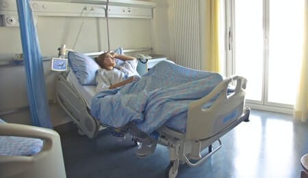pessoa em cuidados paliativos deitada na cama refletindo sobre a vida