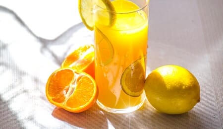 suplemento de vitamina c em um copo de suco de laranja