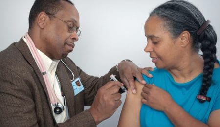 médico homem vacinando mulher