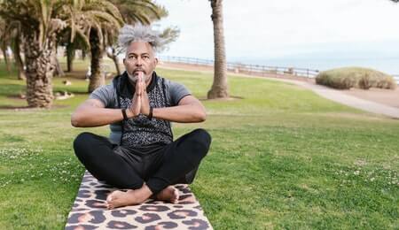 homem meditando na praia para evitar os tipos de depressão