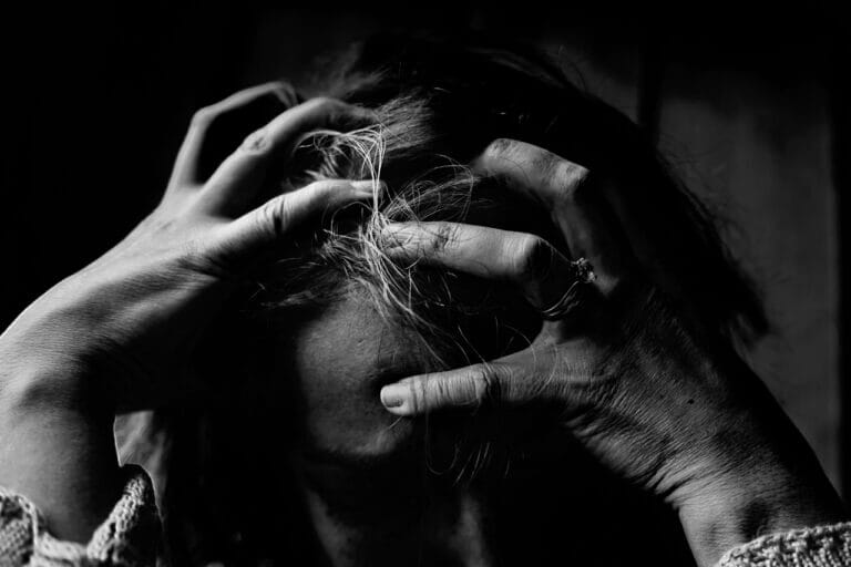 mulher com depressão endógena apertando sua cabeça em preto e branco