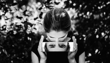 mulher olhando para si mesma no espelho em preto e branco