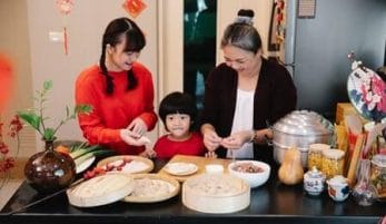 família com uma criança uma jovem e uma mulher superando a crise de meia idade cozinhando com a família