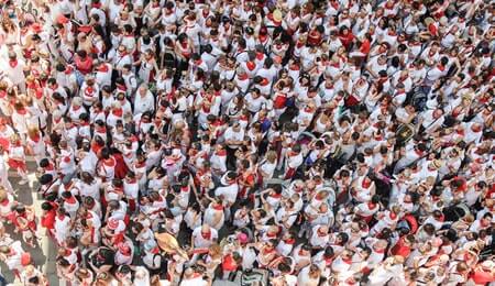 multidão de pessoas vestindo branco e vermelho com a volta às aulas presenciais