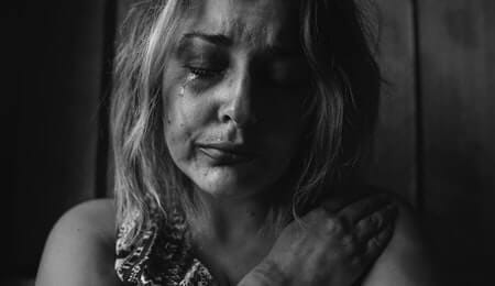 mulher em preto e branco chorando com cara de tristeza