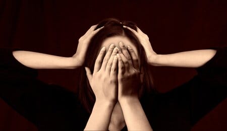 mulher com depressão psicótica vendo duas mãos apertando sua cabeça