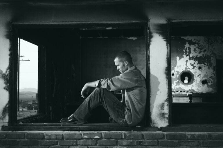 homem com transtorno de personalidade esquizoide sentado na parede e isolado