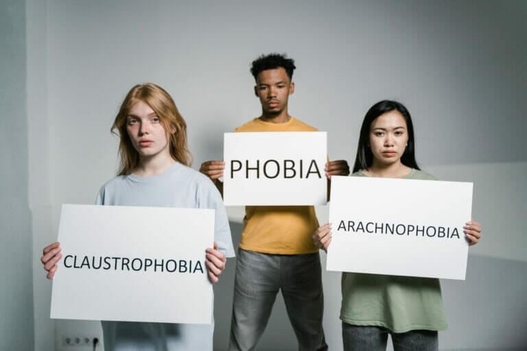 pessoas segurando cartazes com vários tipos de fobias