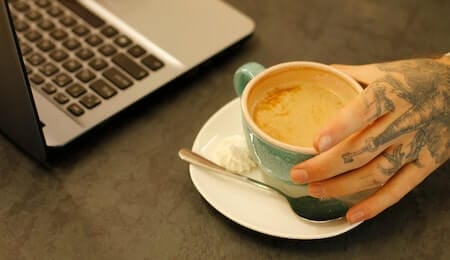 foto de uma pessoa segurando uma xícara de café para mostrar a relação entre sono e ansiedade