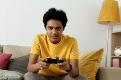 adolescente jogando video game até tarde pode ser um dos motivos de atrasar para a escola