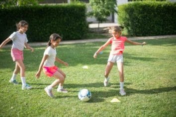 crianças jogando futebol fazendo brincadeiras ao ar livre