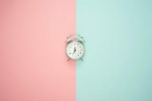 relógio com cores azul e rosa no fundo para o teste de cronotipo do sono