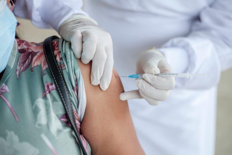 pessoa tomando dose vacina bivalente no braço
